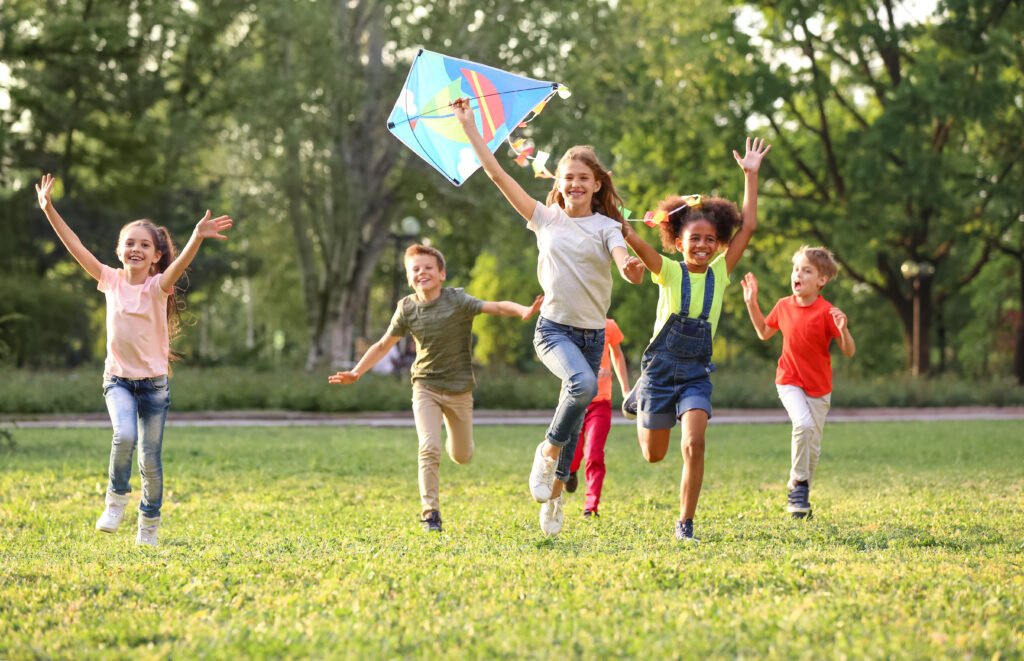 Cute little children playing with kite outdoors on sunny day